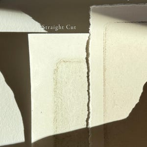 May include: Two pieces of paper, one with a straight edge and the other with a torn edge. The paper with the straight edge has the text "Straight Cut" printed on it. The paper with the torn edge has the text "Torn Edge" printed on it.