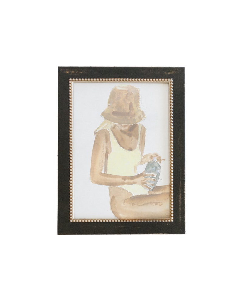 Peut inclure: Une peinture &agrave; l'aquarelle d'une personne portant un maillot de bain jaune et un chapeau de paille marron, tenant une bouteille dans ses mains. La peinture est encadr&eacute;e dans un cadre noir avec une bordure dor&eacute;e.