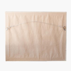 May include: The back of a framed print with a wire hanger and a kraft paper backing. The text on the back reads "Ready to hang. Archival Kraft Paper Backing. Choose the 'Framed' option to receive with frame. Otherwise, print ships unframed."