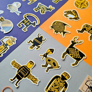 May include: A set of yellow and black patterned stickers featuring various animal and human figures. The stickers are on a purple and orange background.