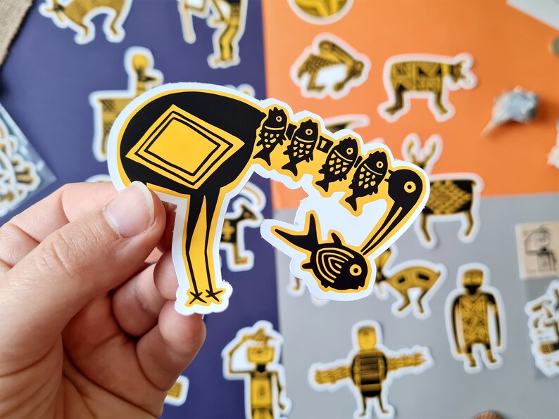 May include: A black and yellow sticker of a bird carrying a string of fish. The bird has a square shape on its back and a long neck. The fish are yellow and black with a white outline.