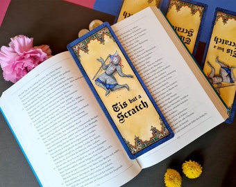 May include: A blue and gold bookmark with a medieval knight illustration and the text "Tis but a Scratch".