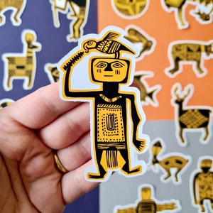 May include: A yellow and black sticker of a stylized human figure holding a bird above its head. The figure is wearing a patterned headdress and a patterned skirt. The sticker is on a white background.