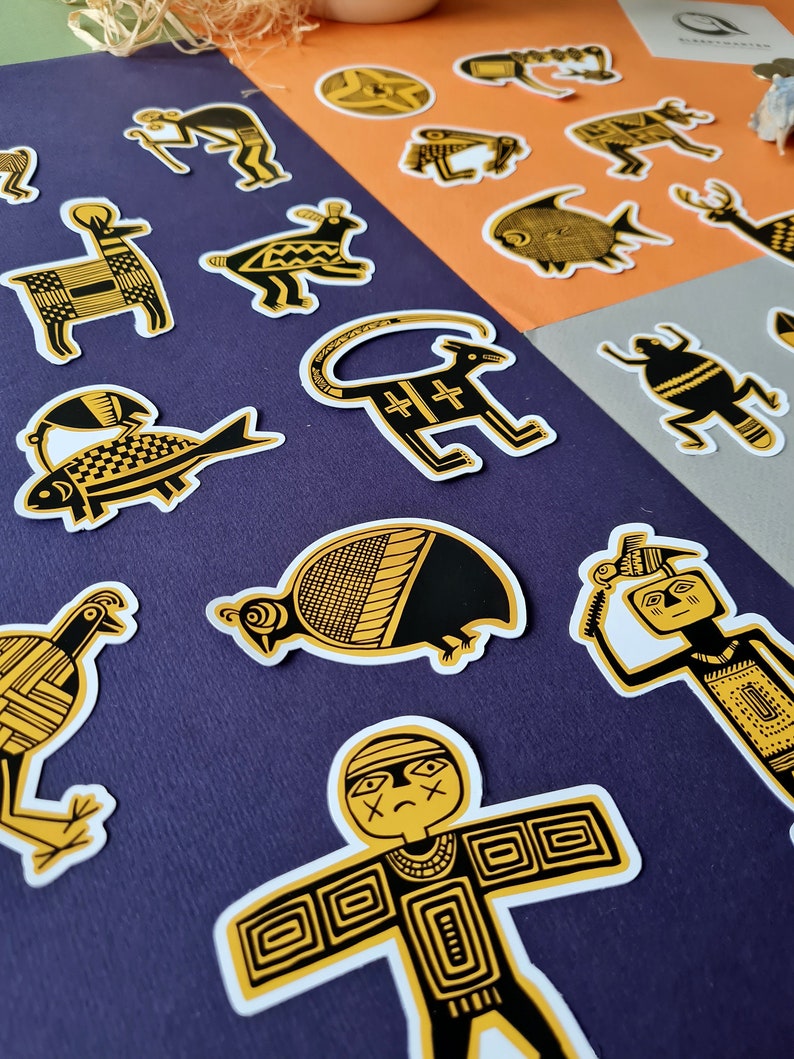 May include: A set of 14 black and gold stickers featuring various animal and human figures. The stickers are on a purple background. The stickers are all in a stylized, geometric style.