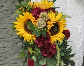 Cascading Boho Brides Sunflower and burgundy mums with eucalyptus, berries, scabosia and amaranthus.