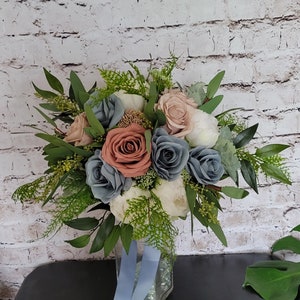 Boho Brides wedding bouquet with dusty rose, dusty blue and white. Roses, peonies and greenery.
