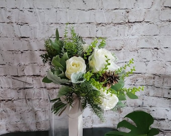 Winter Boho bouquet with White roses, and pine cones, evergreen and eucalyptus and dusty miller.