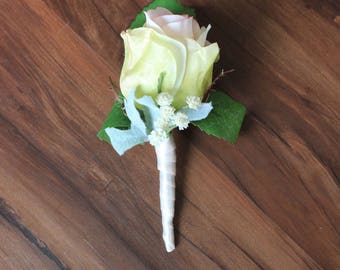 Boutinniere wedding garden with rose bud in blush. Dusty miller and babys breath.