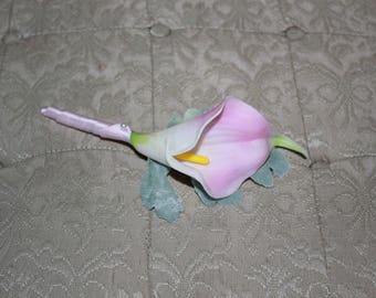 Boutinniere in real touch pink calla lily with accents of dusty miller and Euphorbia. Wrapped in white satin. Weddings or prom.
