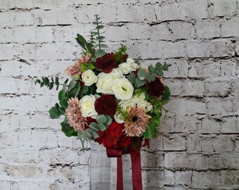 Brides wedding bouquet in burgundy and dusty rose double sunflowers, white roses, ranunculus and peonies. Eucalyptus, ficus and rosemary.