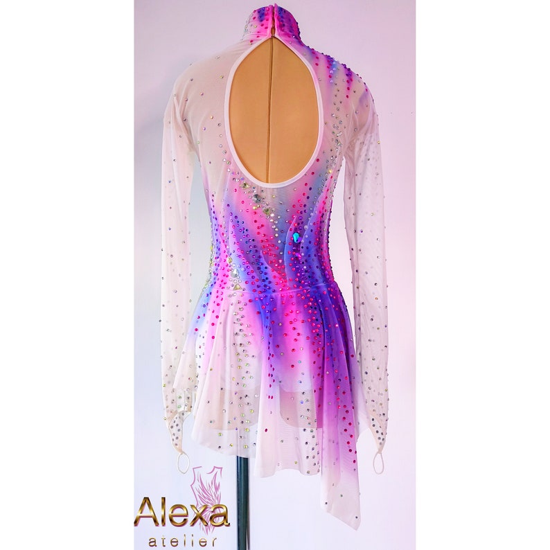May include: White figure skating dress with a pink, purple, and blue ombre design. The dress has long sleeves and a keyhole back. The dress is decorated with rhinestones.