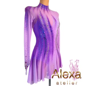 Pu&ograve; includere: Un abito da pattinaggio artistico di colore viola con maniche lunghe e collo alto. L'abito &egrave; decorato con strass iridescenti e presenta un design sfumato. L'abito &egrave; realizzato in un tessuto trasparente e ha una gonna svasata.