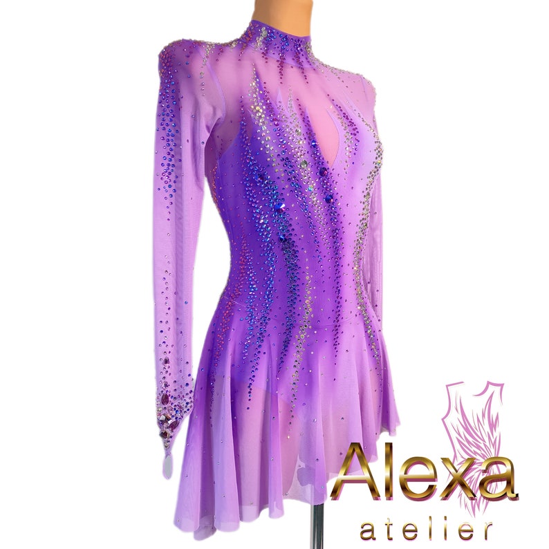 Pu&ograve; includere: Un abito da pattinaggio artistico di colore viola con maniche lunghe e collo alto. L'abito &egrave; decorato con strass iridescenti e presenta un design sfumato. L'abito &egrave; realizzato in un tessuto trasparente e ha una gonna svasata.