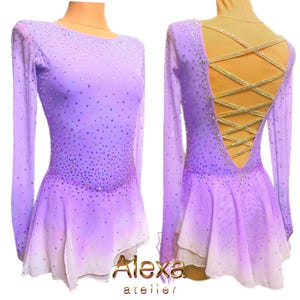 May include: A lavender figure skating dress with a white ombre effect and a criss-cross back design. The dress is embellished with iridescent rhinestones.