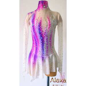 May include: A white figure skating dress with long sleeves and a pink, purple, and white ombre design. The dress is embellished with rhinestones.