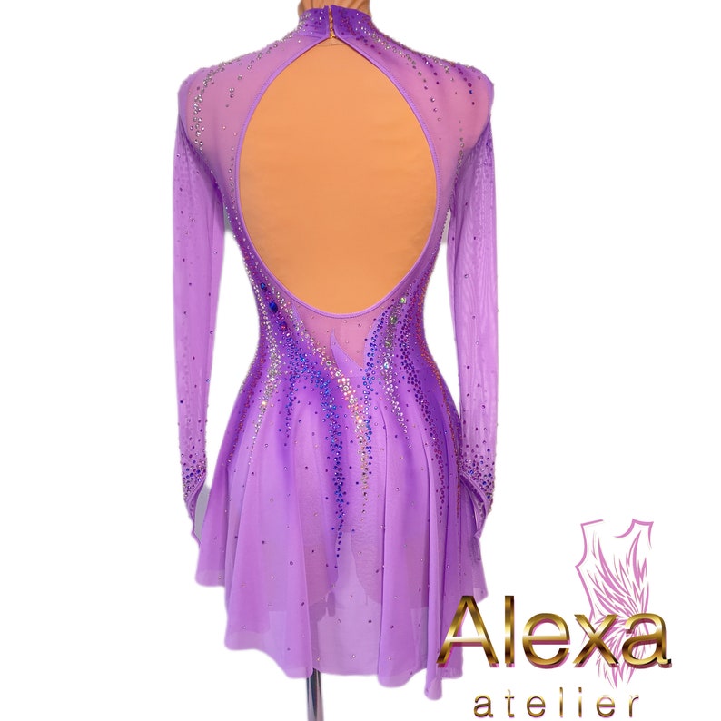 Pu&ograve; includere: Un abito da ballo color lavanda con maniche lunghe e un corpetto trasparente. L'abito ha una grande schiena aperta ed &egrave; decorato con strass.