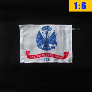 May include: A white flag with a blue United States Army emblem and the words "United States Army 1775" in red.
