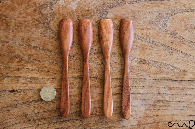 Puede incluir: Cuatro cuchillos de mantequilla de madera con bordes redondeados y un acabado de madera natural.
