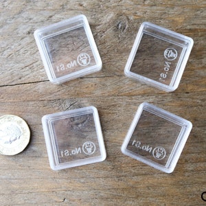 May include: Four clear plastic square containers with the text "No. 1" printed on each container.