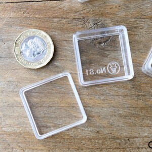 May include: Four clear plastic square boxes with a raised lip around the edges. The boxes are empty and have the text "No. 2" printed on the bottom.
