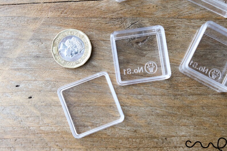 May include: Four clear plastic square boxes with a raised lip around the edges. The boxes are empty and have the text "No. 2" printed on the bottom.