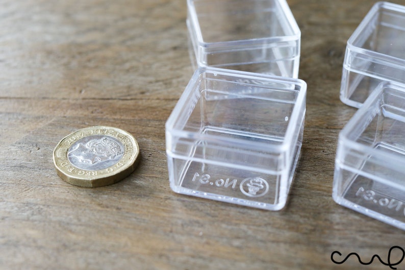 May include: Four clear plastic square boxes with lids. The boxes are stacked on top of each other. The boxes are labeled with the text "No. 3."