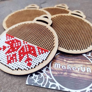 Kreuzstichstickerei Rohling aus Holz, verziert mit Ornamenten, gesticktes Kreuzstichmuster, runder Anhänger, Stickmuster, Faden, Anleitung, Anleitung zum nähen