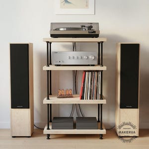 May include: A wooden audio rack with a turntable, amplifier, and vinyl records. Two tall speakers flank the rack. The rack has four shelves with black metal supports. A small decorative light displays the numbers 2010.