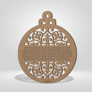 K&ouml;nnte beinhalten: Ein Weihnachtsornament aus Holz mit einem aufwendigen, durchbrochenen Design. Das Ornament ist hellbraun und weist eine Reihe kleiner L&ouml;cher zum Sticken oder Verzieren auf. Das Design umfasst florale und scrollartige Muster. Der Text "MakerUA" ist unten sichtbar.