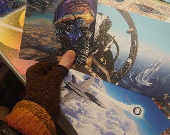 May include: A set of three colorful prints featuring a pilot in a cockpit, a fighter jet flying through clouds, and a geometric design with a galaxy background.