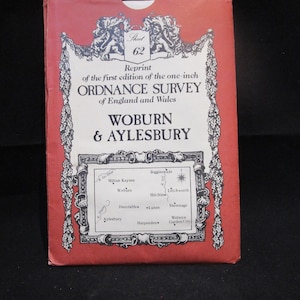 May include: Red paper cover with a black and white illustration of a map of England and Wales. The cover includes the text "Sheet 62", "Reprint of the first edition of the one-inch Ordnance Survey of England and Wales", "Woburn & Aylesbury", and a list of towns and cities including Milton Keynes, Woburn, Dunstable, Aylesbury, Hitchin, Litchworth, Stovesage, Welwyn Garden City, Biggleswade, and Harpenden.