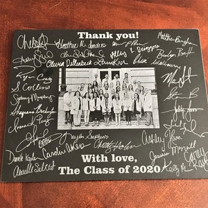 May include: Black and white photo of a group of people in white coats standing on a set of stairs. The photo is surrounded by handwritten signatures and the text "Thank you!" and "With love, The Class of 2020".
