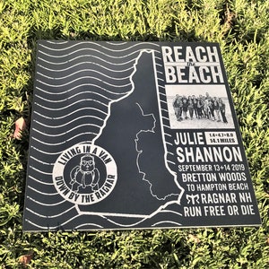 May include: Black and white sign with a map of a running route. The sign says "Reach the Beach" and "Living in a Van Down by the Ragnar". It also includes the name "Julie Shannon" and the dates "September 13+14 2019". The sign says "Bretton Woods to Hampton Beach Ragnar NH Run Free or Die".
