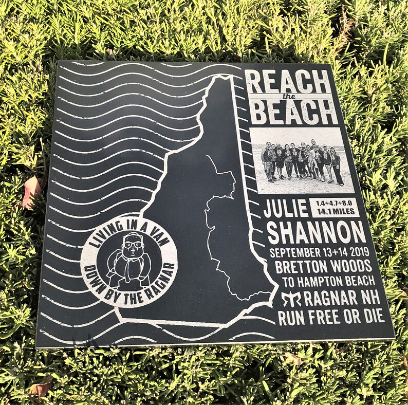 May include: Black and white sign with a map of a running route. The sign says "Reach the Beach" and "Living in a Van Down by the Ragnar". It also includes the name "Julie Shannon" and the dates "September 13+14 2019". The sign says "Bretton Woods to Hampton Beach Ragnar NH Run Free or Die".