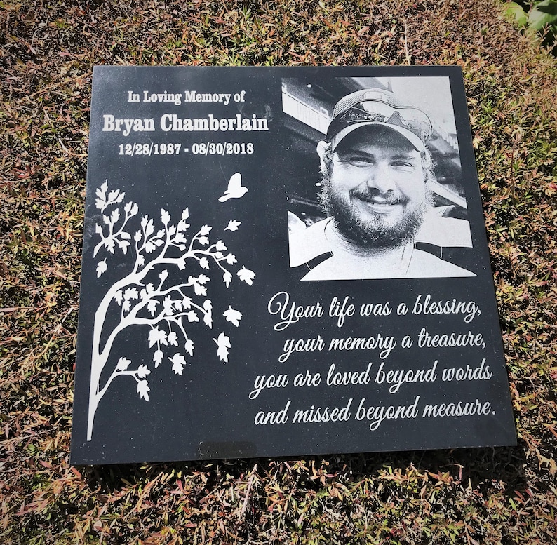 May include: Black granite memorial stone with a white etched tree, a photo of a man, and the text "In Loving Memory of Bryan Chamberlain 12/28/1987 - 08/30/2018 Your life was a blessing, your memory a treasure, you are loved beyond words and missed beyond measure."