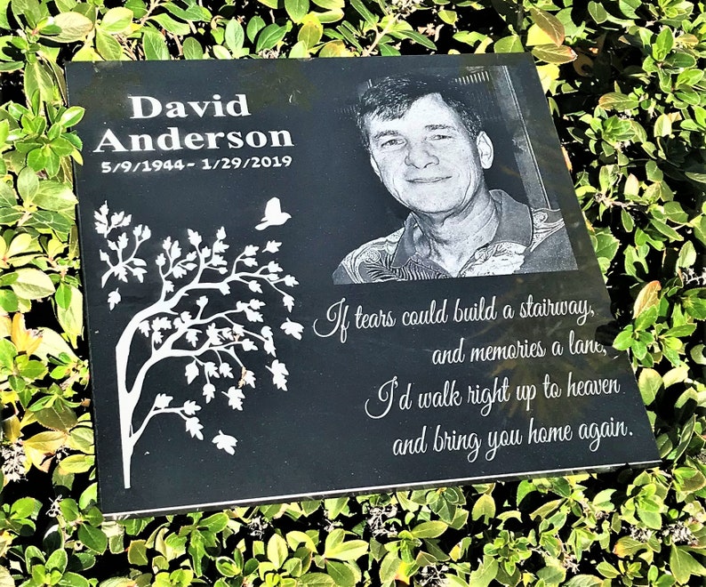 May include: Black granite memorial plaque with a white tree design, a photo of a man, and the text "David Anderson 5/9/1944-1/29/2019". The plaque also includes a poem: "If tears could build a stairway, and memories a lane, I'd walk right up to heaven and bring you home again."