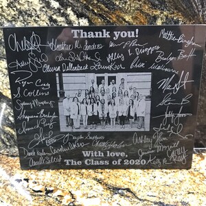 May include: Black granite plaque with a group photo of people in white coats and the text "Thank you!" and "The Class of 2020" with many signatures in white.