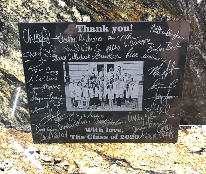 May include: Black granite plaque with a group photo of people in white coats and the text "Thank you!" and "The Class of 2020" with many signatures in white.