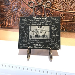 May include: A black and white photo of a graduating class with signatures and the text "Thank you!" and "The Class of 2020" on a black background.