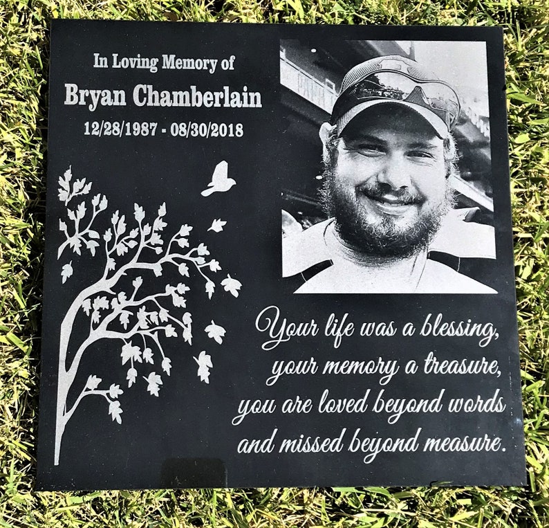 May include: Black granite memorial stone with a photo of a man, a tree with leaves, and the text "In Loving Memory of Bryan Chamberlain 12/28/1987 - 08/30/2018 Your life was a blessing, your memory a treasure, you are loved beyond words and missed beyond measure."
