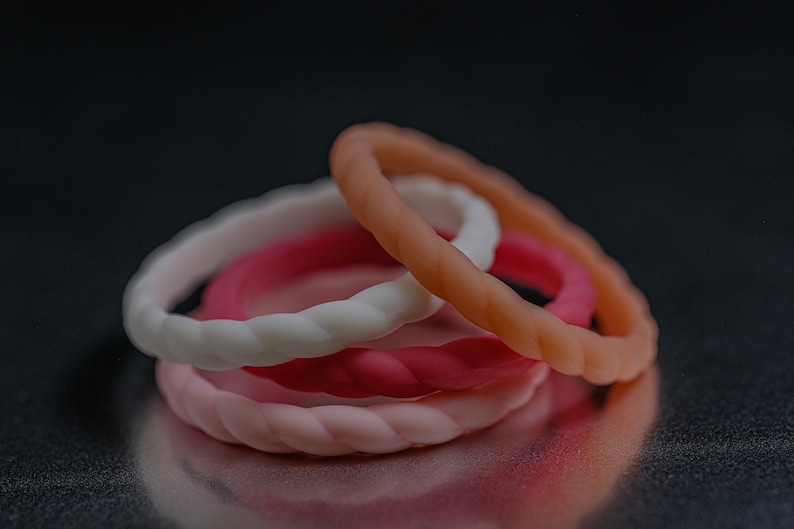 4 different styles of pink silicone bands in a braided style.
