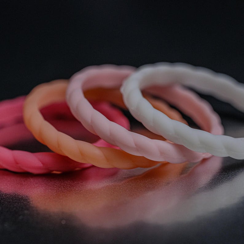 4 different styles of pink silicone bands in a braided style.