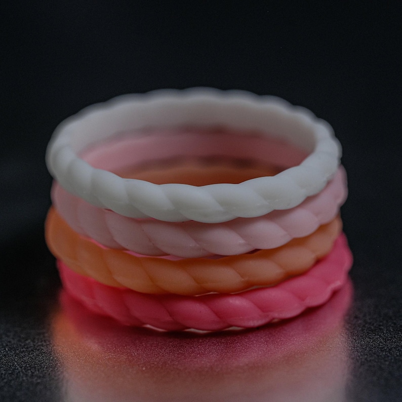 4 different styles of pink silicone bands in a braided style.