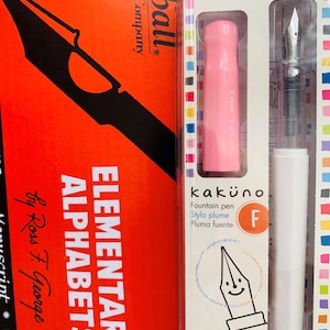 Può includere: Una penna stilografica Pilot Kakuno rosa e bianca con un pennino fine, confezionata in una scatola di plastica trasparente con accenti colorati. La scatola presenta il testo "kakuno" e "Penna stilografica" in bianco e nero.