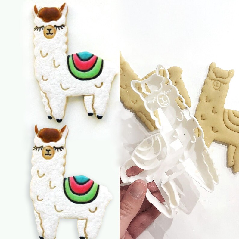 May include: Two llama-shaped cookies with white frosting, brown ears, and colorful saddle blankets. The cookies have black eyes and feet. A clear plastic llama cookie cutter is also shown, along with a baked cookie.