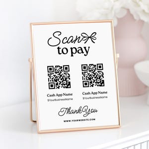 May include: A white sign with a gold frame on a stand. The sign says "Scan to pay" with two QR codes and the text "Cash App Name $YourBusinessName" below each code. The sign also says "Thank You" and "WWW.YOURWEBSITE.COM".