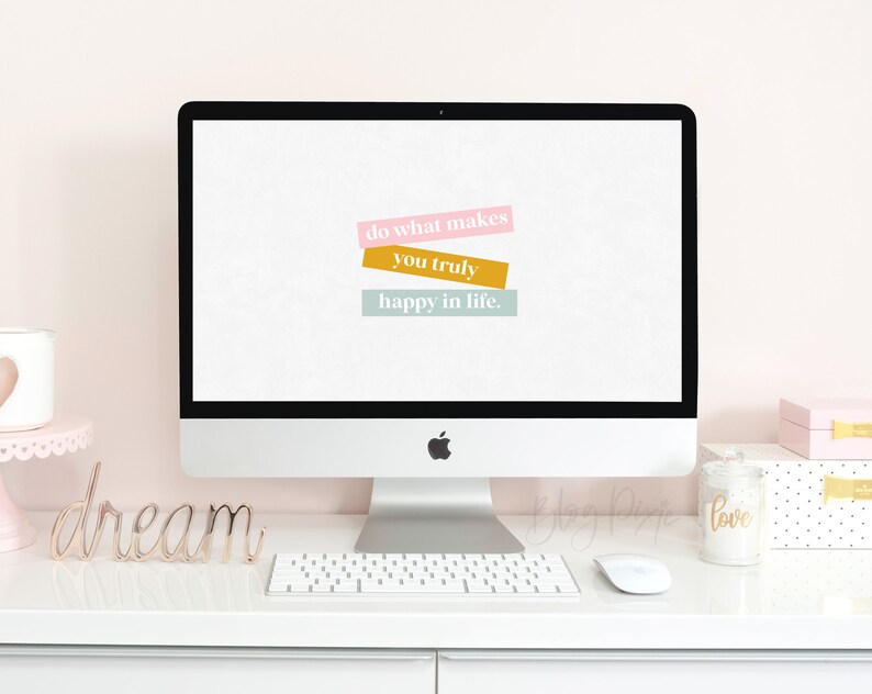 Puede incluir: Un ordenador de sobremesa blanco con una cita motivacional en la pantalla que dice "haz lo que te haga realmente feliz en la vida". La cita se muestra en una fuente colorida y en capas. El ordenador est&aacute; sobre un escritorio blanco con la palabra "sue&ntilde;o" en metal dorado y un teclado blanco delante.