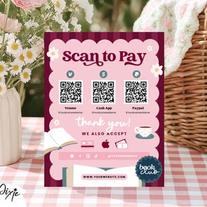 May include: A pink and burgundy sign with the text "Scan to Pay" and QR codes for Venmo, Cash App, and PayPal. The sign also says "thank you!" and "WE ALSO ACCEPT" with icons for credit cards and Apple Pay. The sign has a floral design and the words "book club".