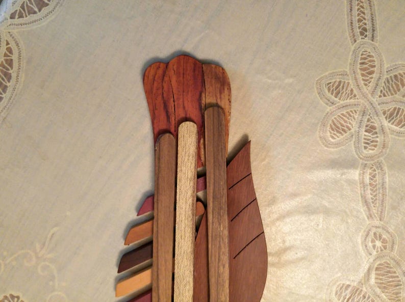 K&ouml;nnte beinhalten: Ein Wandkunstwerk aus Holz mit einem einzigartigen Design. Das St&uuml;ck besteht aus verschiedenen Holzarten, jede mit einer anderen Farbe und Maserung. Das Holz ist so angeordnet, dass ein dreidimensionaler Effekt entsteht. Das St&uuml;ck ist perfekt, um jedem Raum einen Hauch von Natur zu verleihen.