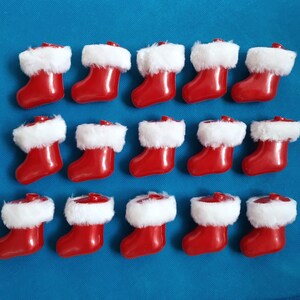 May include: A collection of 12 red and white Christmas stockings with white fur trim. The stockings are arranged in three rows of four.